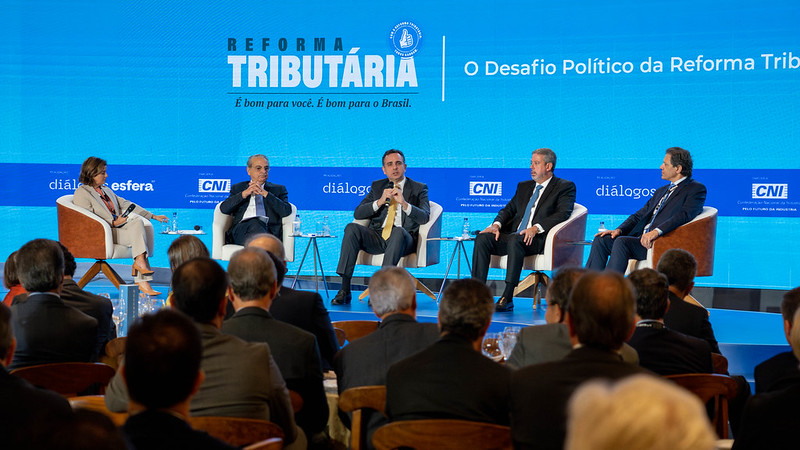 Fotografia colorida de quatro homens e uma mulher na Seminário “Reforma Tributária: a hora é agora” da CNI