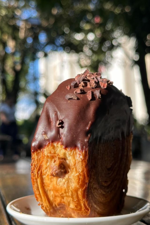 Foto colorida de um croissant redondo com cobertura - Metrópoles