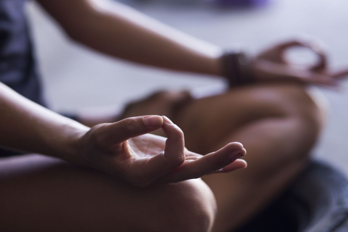 Foto mostra uma pessoa praticando a meditação