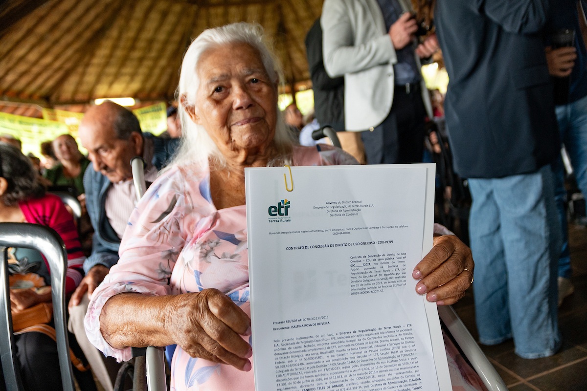 Fotografia colorida de um trabalhador rural recebendo o CDU em evento da ETR