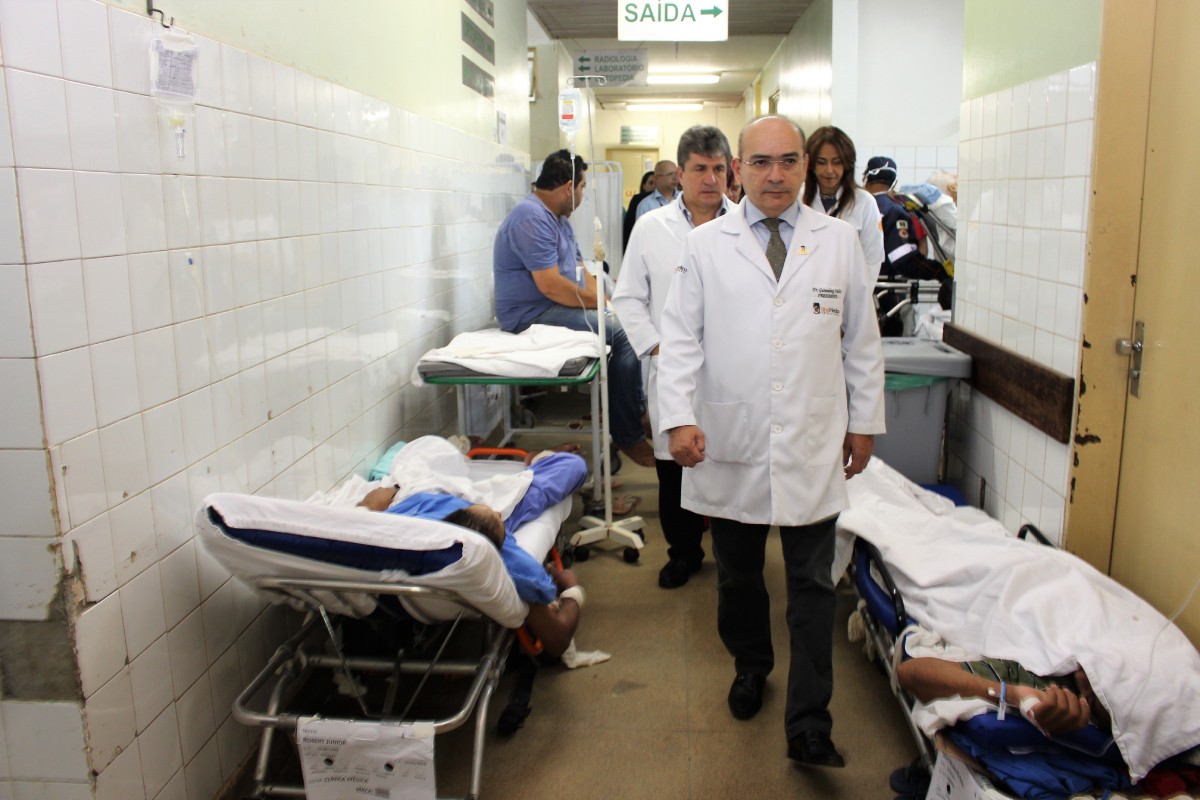 Fotografia colorida mostrando médico andando entre pacientes em emergência de hospital-Metrópoles