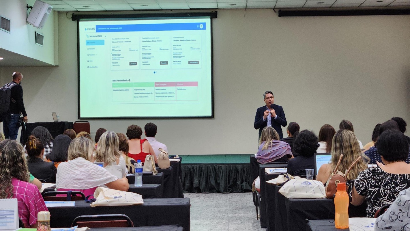 Foto colorida de palestra com adultos na plateia