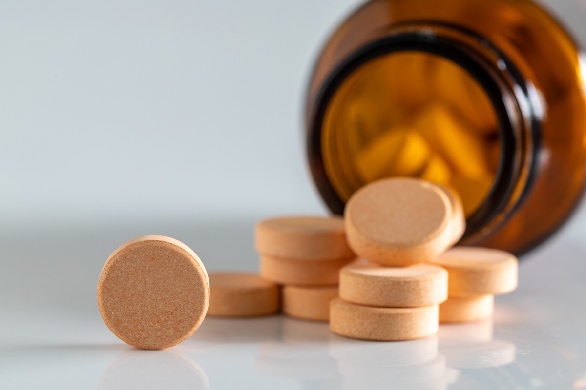Foto de stock de Pílulas de vitamina amarelas isoladas em um fundo branco