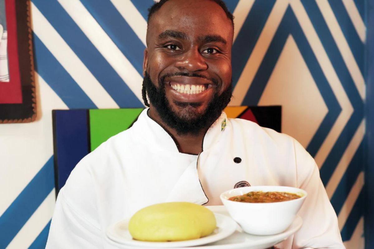 Foto colorida de um homem segurando um prato de comida - Metrópoles