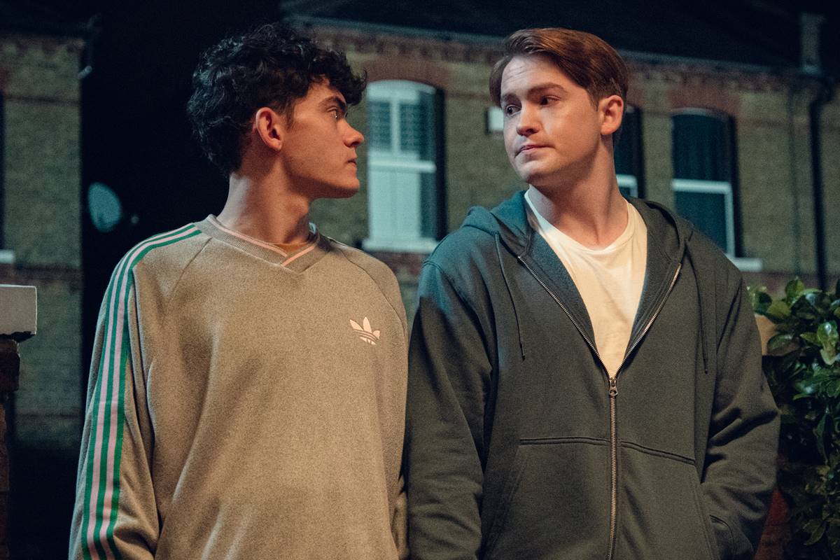 Cena da terceira temporada de Heartstopper mostra Charlie e Nick olhando um para o outro, com roupas de frio - Metrópoles