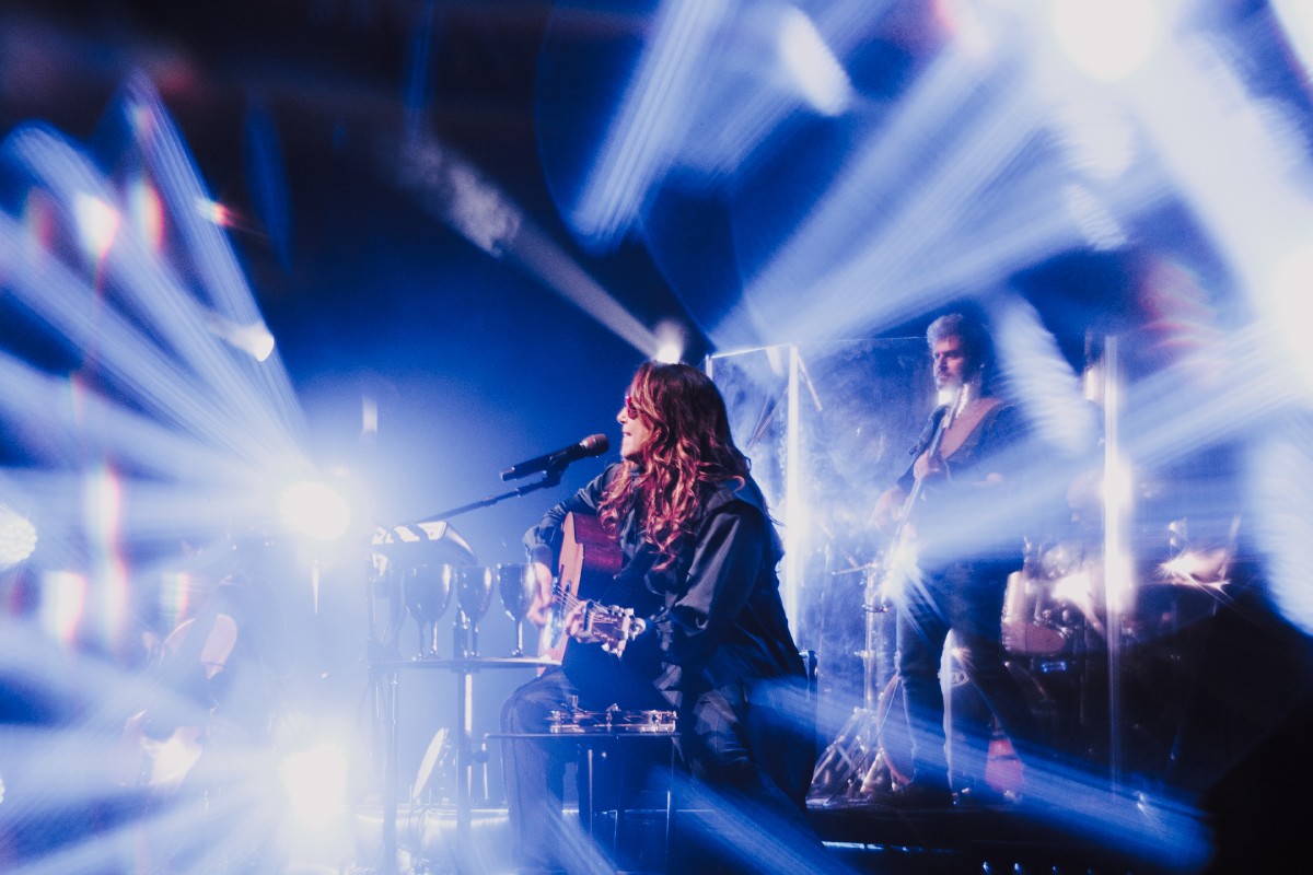 Fotografia colorida mostrando cantora cantando em palco cheio de luzes-Metrópoles