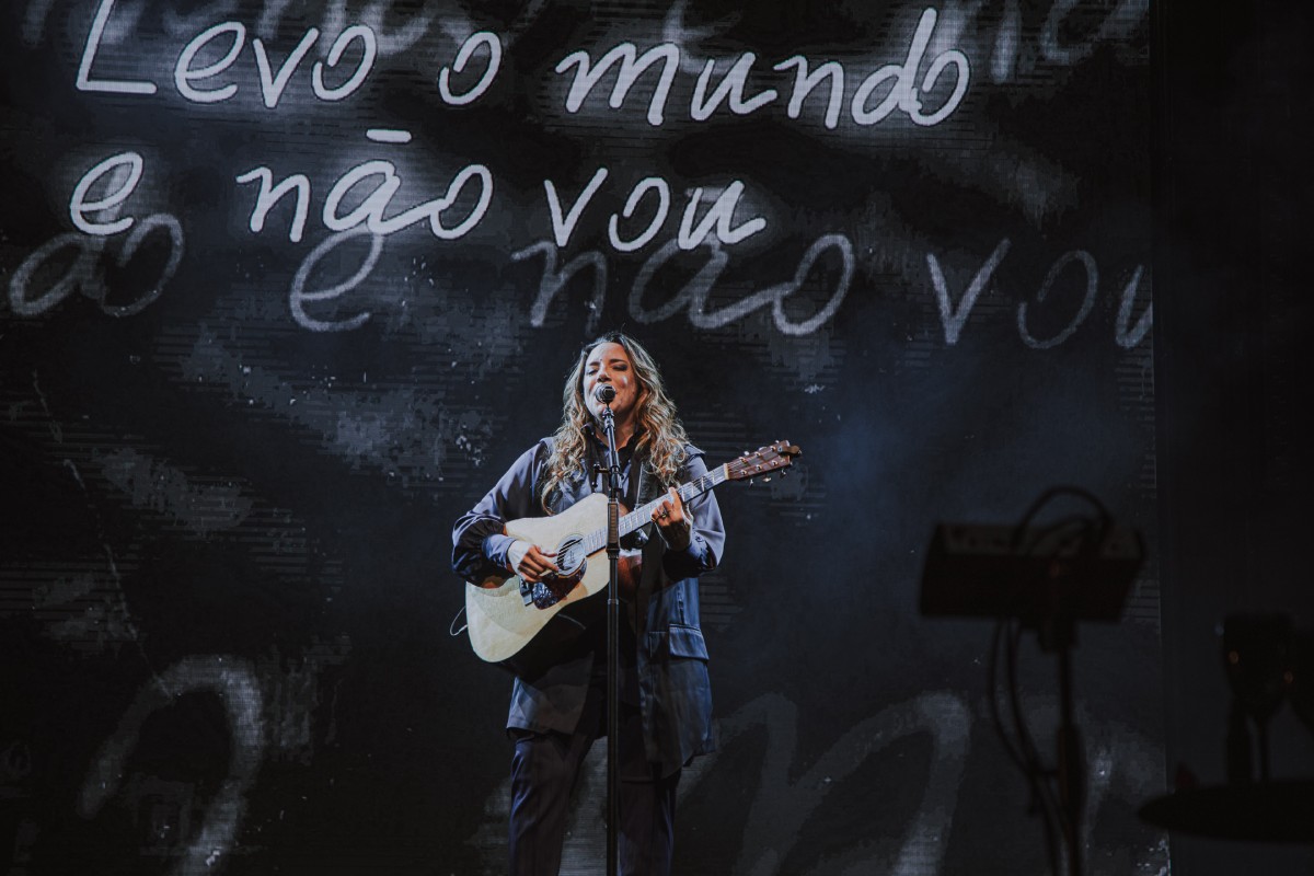 Fotografia colorida mostrando cantora com violão em palco-Metrópoles
