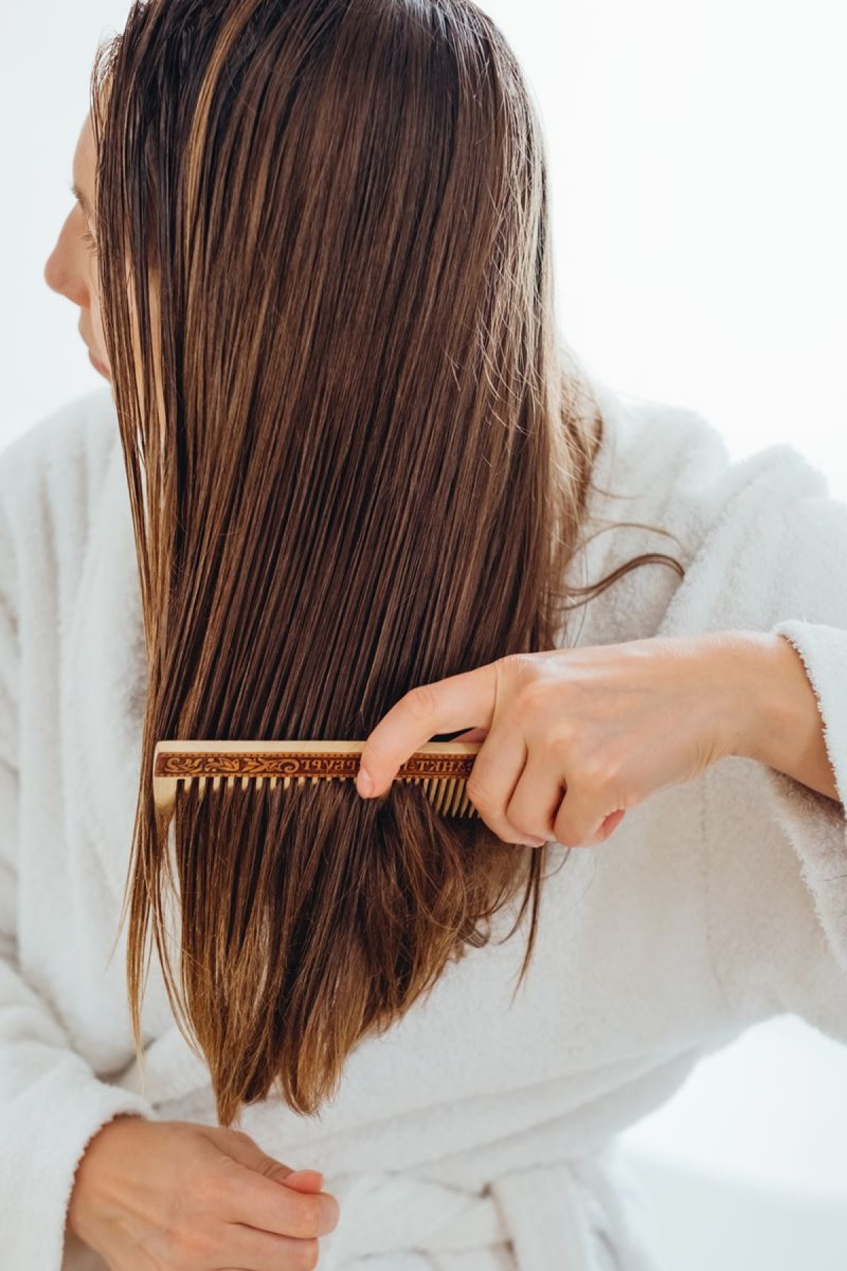 Foto colorida - Mulher penteando o cabelo - loiro