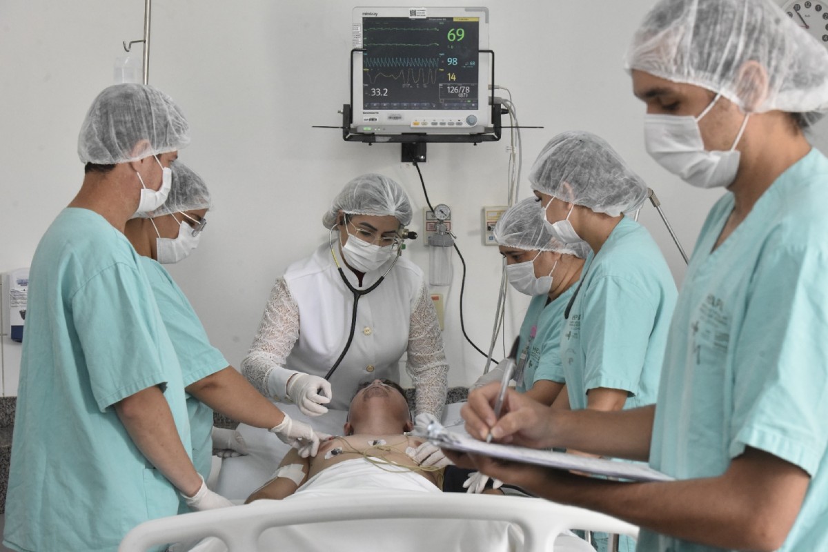 Fotografia colorida mostrando médico e enfermeiros atendendo paciente em cama de hospital-Metrópoles