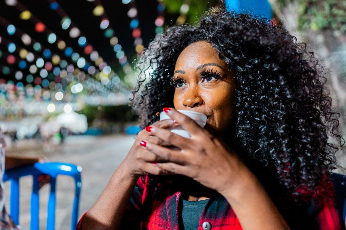 foto mulher negra tomando quentao em festa junina