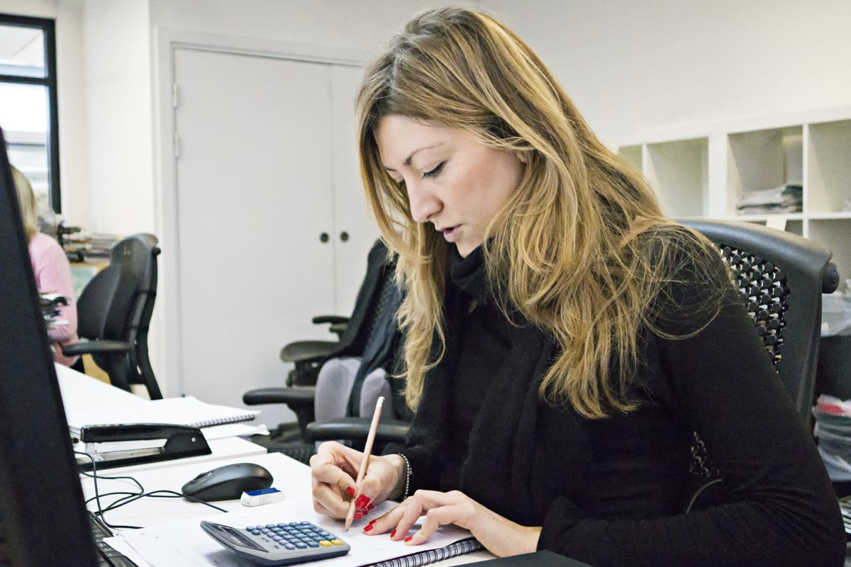 Foto colorida de mulher em escritório trabalhando - Metrópoles