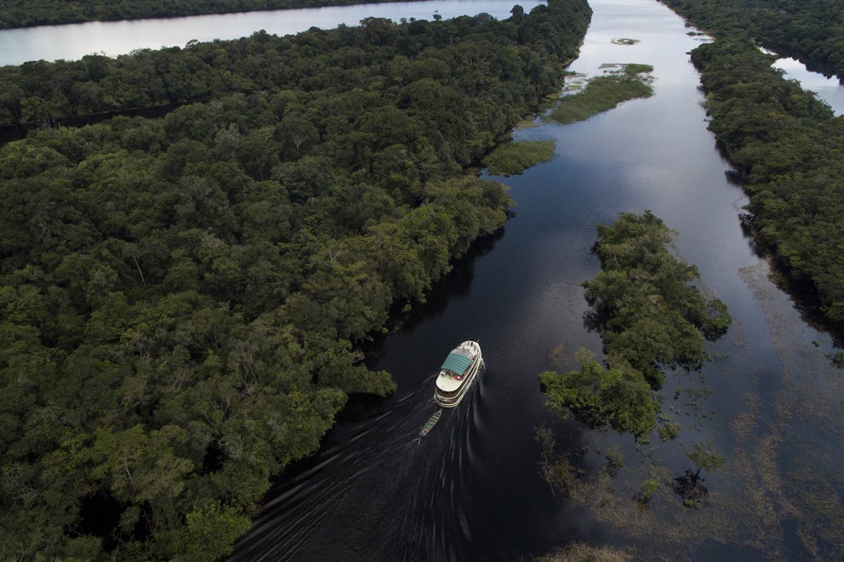 Foto colorida de um barco sobre rio na Amazônia - Metrópoles.
