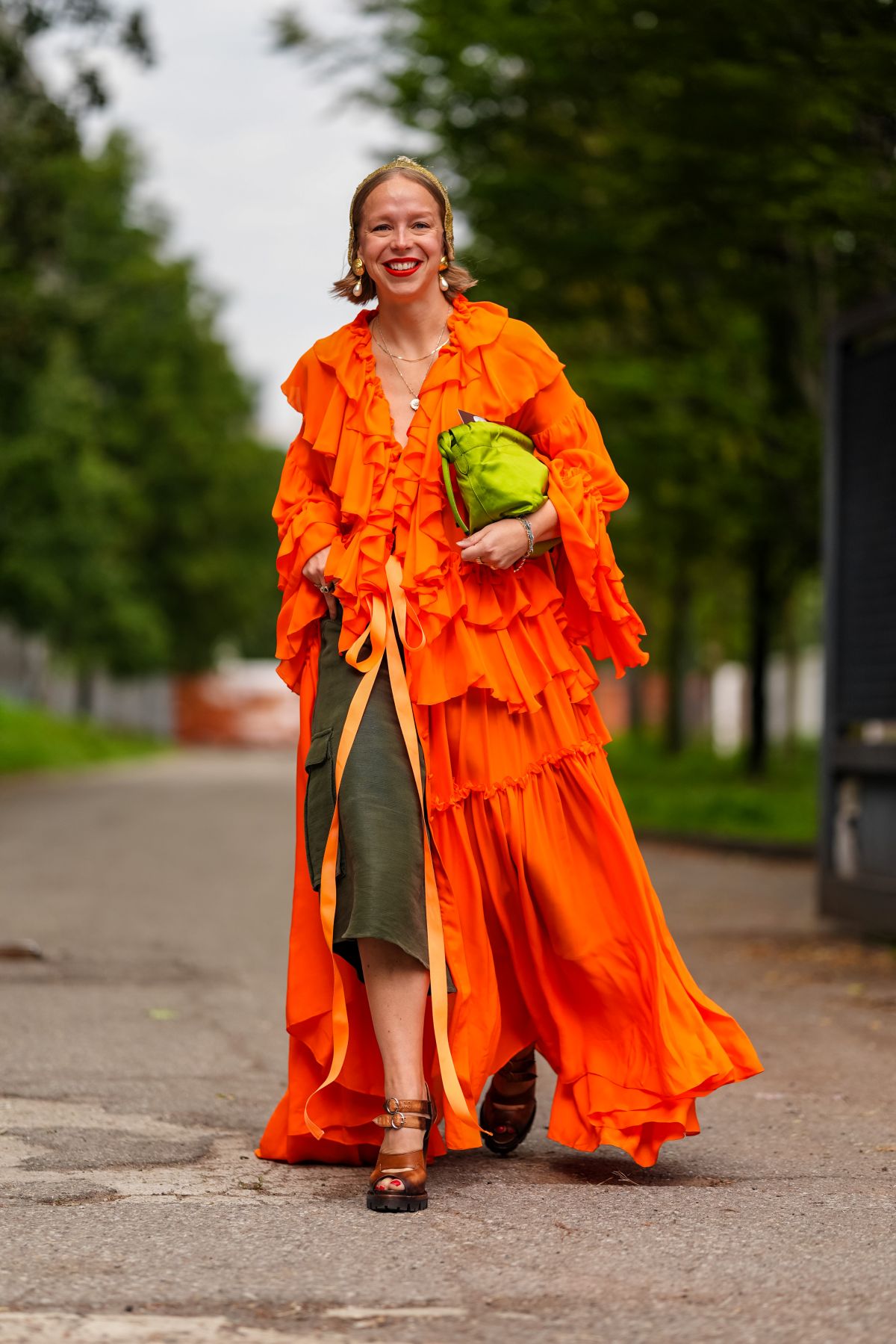 Foto com cor. Mulher usando roupa laranja - Metrópoles