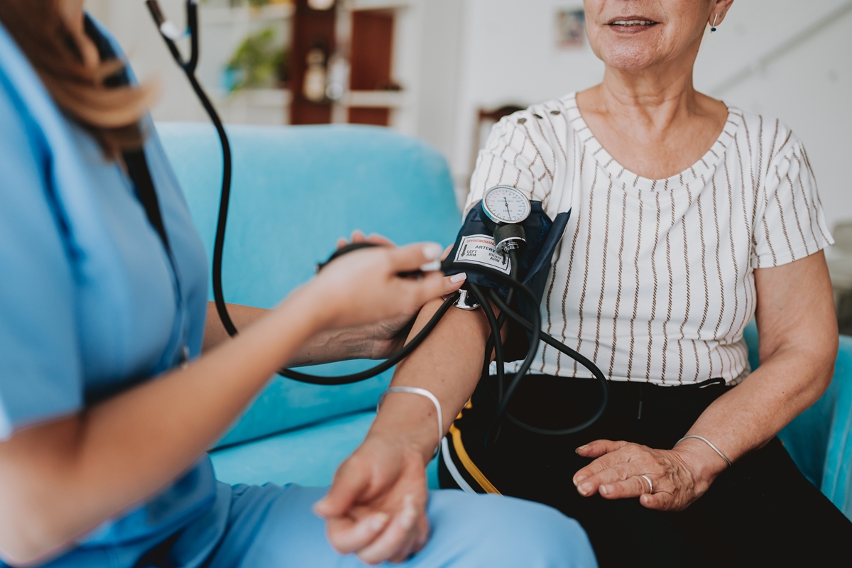 Profissional de saúde mulher medindo pressão arterial de mulher idosa para averiguar hipertensão - Cardiologistas explicam quais são os principais sinais de pressão alta - Metrópoles
