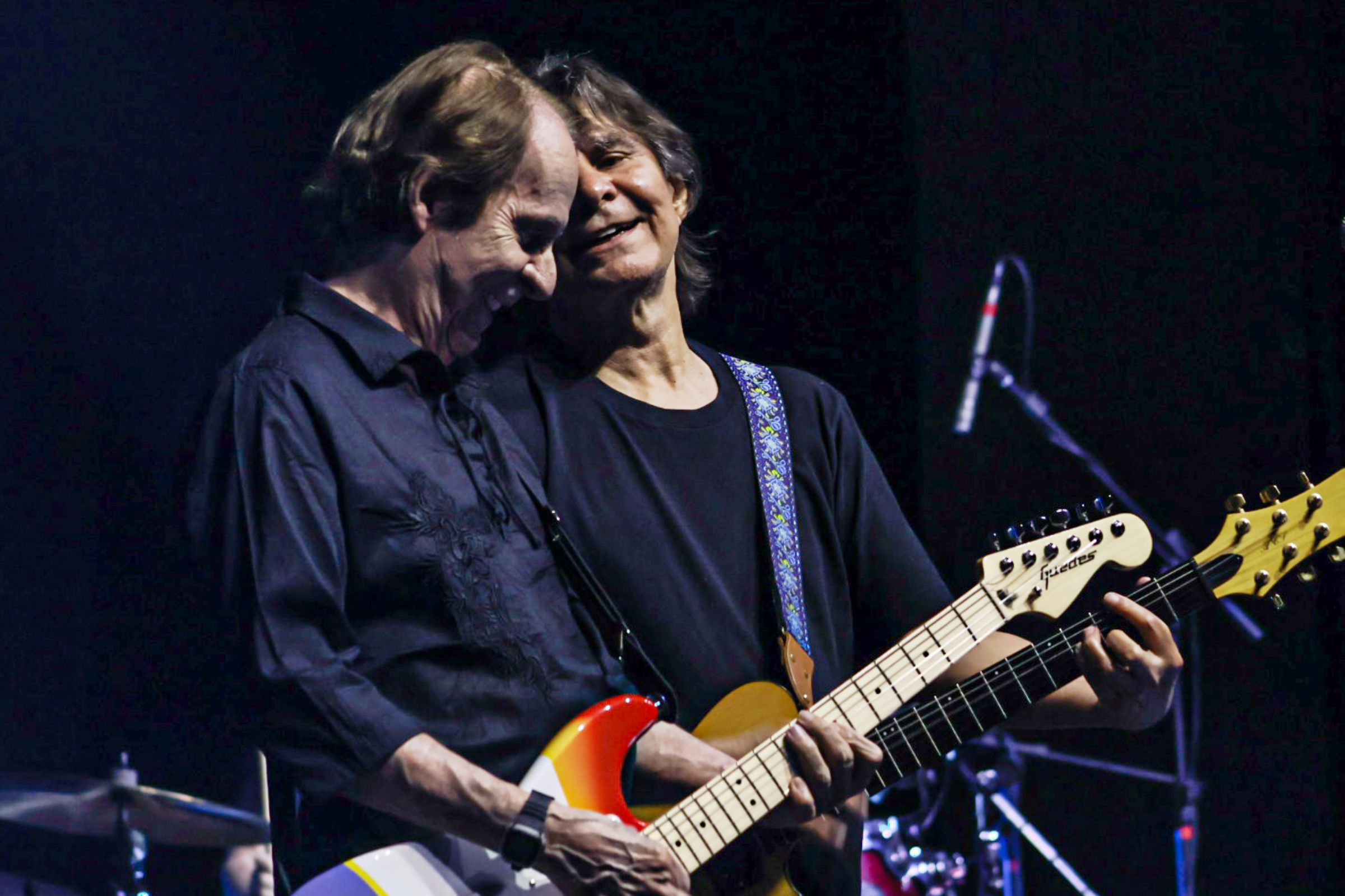 Fotografia colorida mostrando dois homens tocando guitarra-Metrópoles