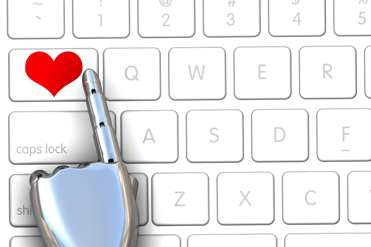 Ilustração de um techado de computador branco, com um braço robótico apertando uma tecla com um coração vermelho - Metrópoles.