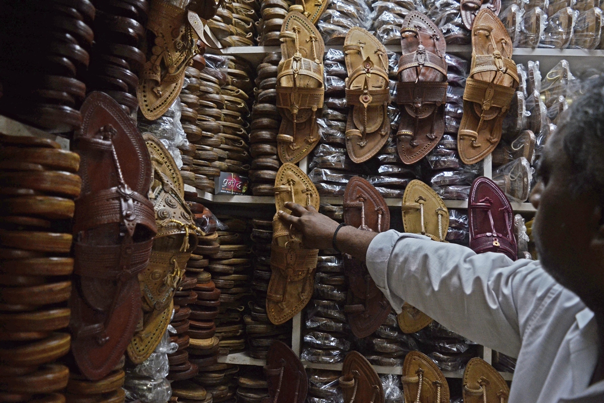 Vendedor mostrando suas Kolhapuri chappals - Metrópoles