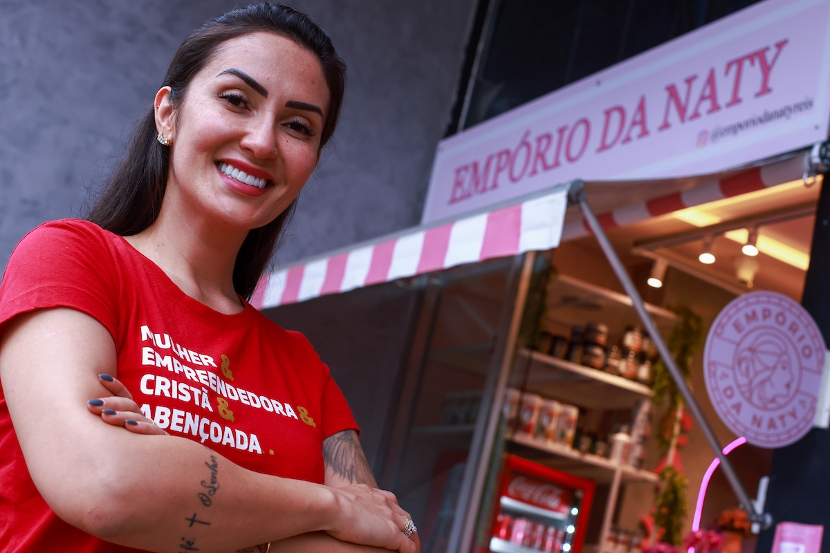 Foto colorida da Natália Reis em frente da loja Empório da Naty - Metrópoles