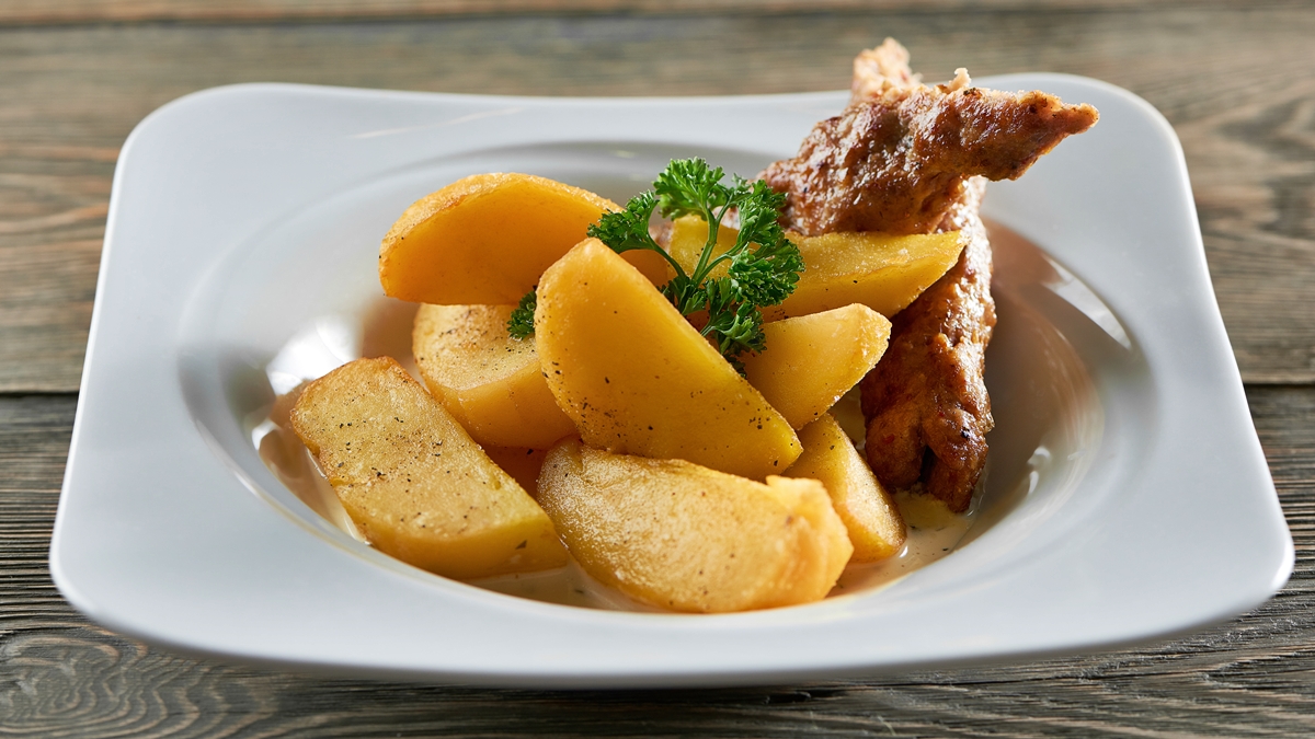 Foto colorida de prato com duas linguiças e batatas