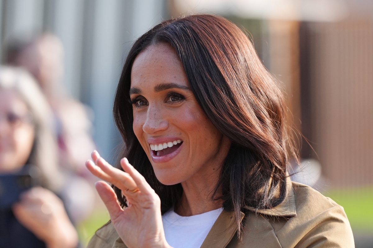 Foto colorida de mulher com cabelo castanho-escuro acenando - Metrópoles