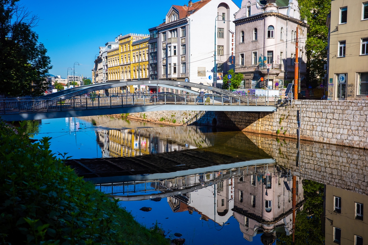 Foto colorida de ponte, lago e edifícios ao redor - Metrópoles