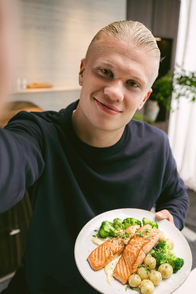 Foto colorida de homem segurando prato com peixe e legumes - Metrópoles