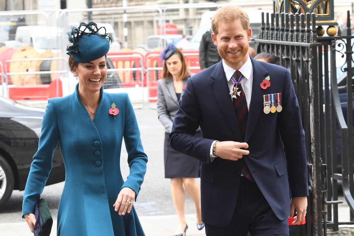 Foto colorida de mulher com roupa azul e homem com terno e medalhas militares. Eles estão andando e sorrindo - Metrópoles