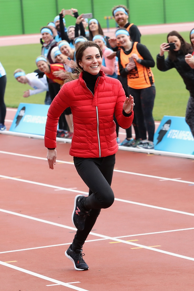Foto colorida de mulher com casaco vermelho correndo em pista de ciclismo - Metrópoles