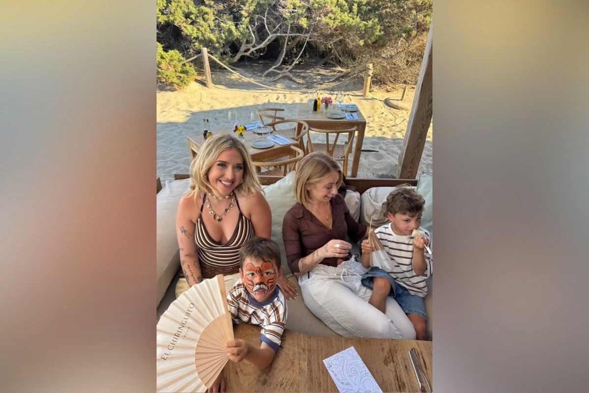 Foto colorida de Leah Barrs com crianças e outra mulher