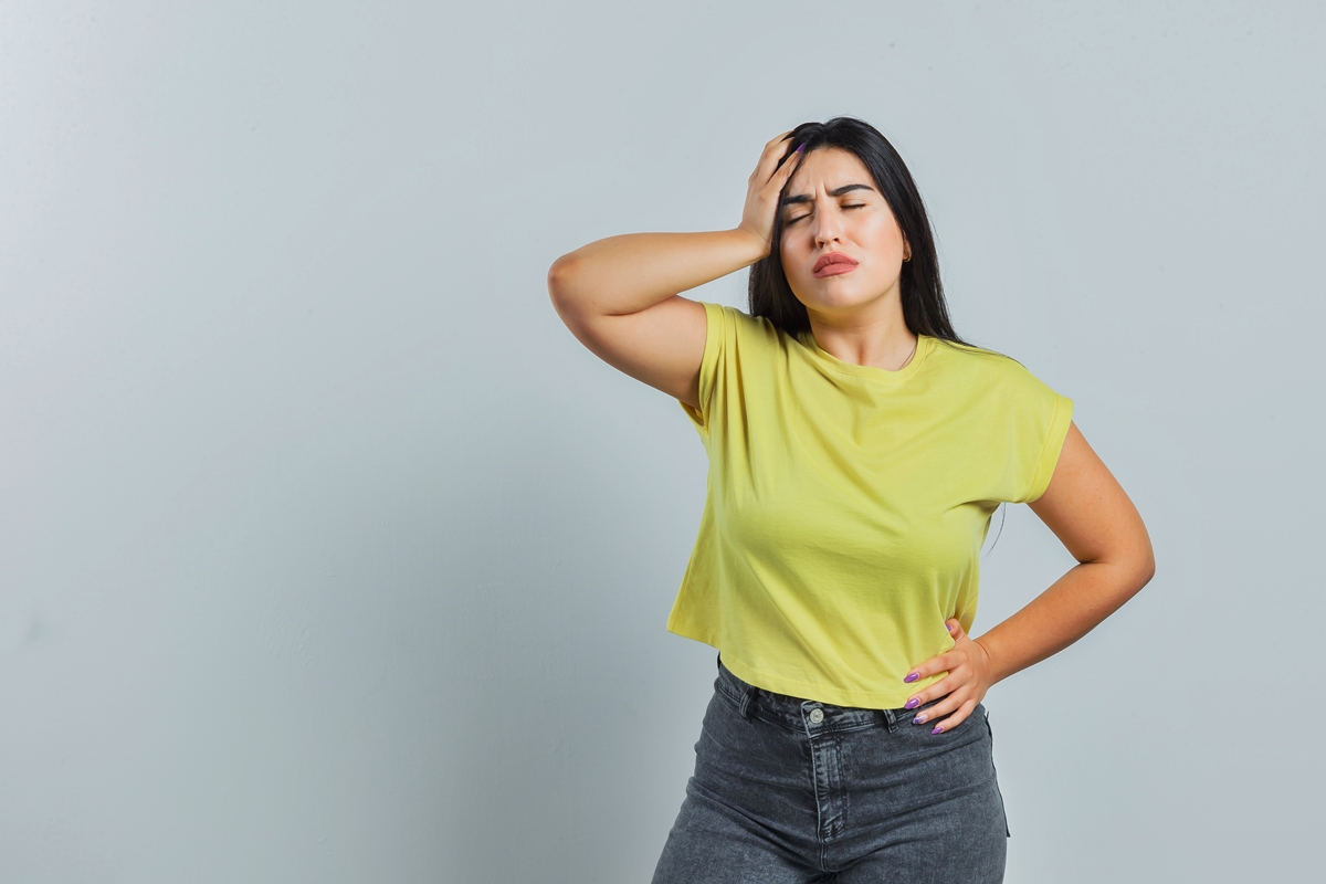 Foto colorida de mulher sentindo dor na barriga