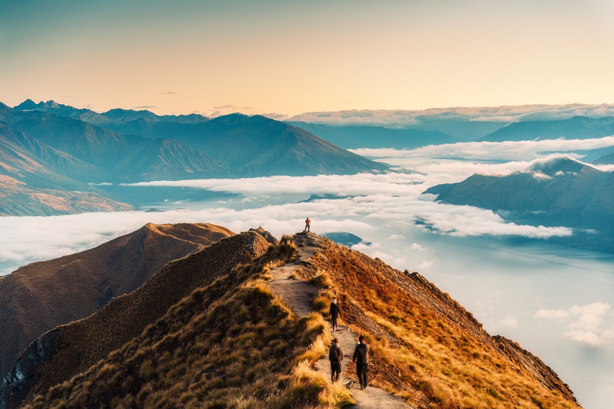 Foto colorida de nuvens ao redor de monte com pessoas - Metrópoles