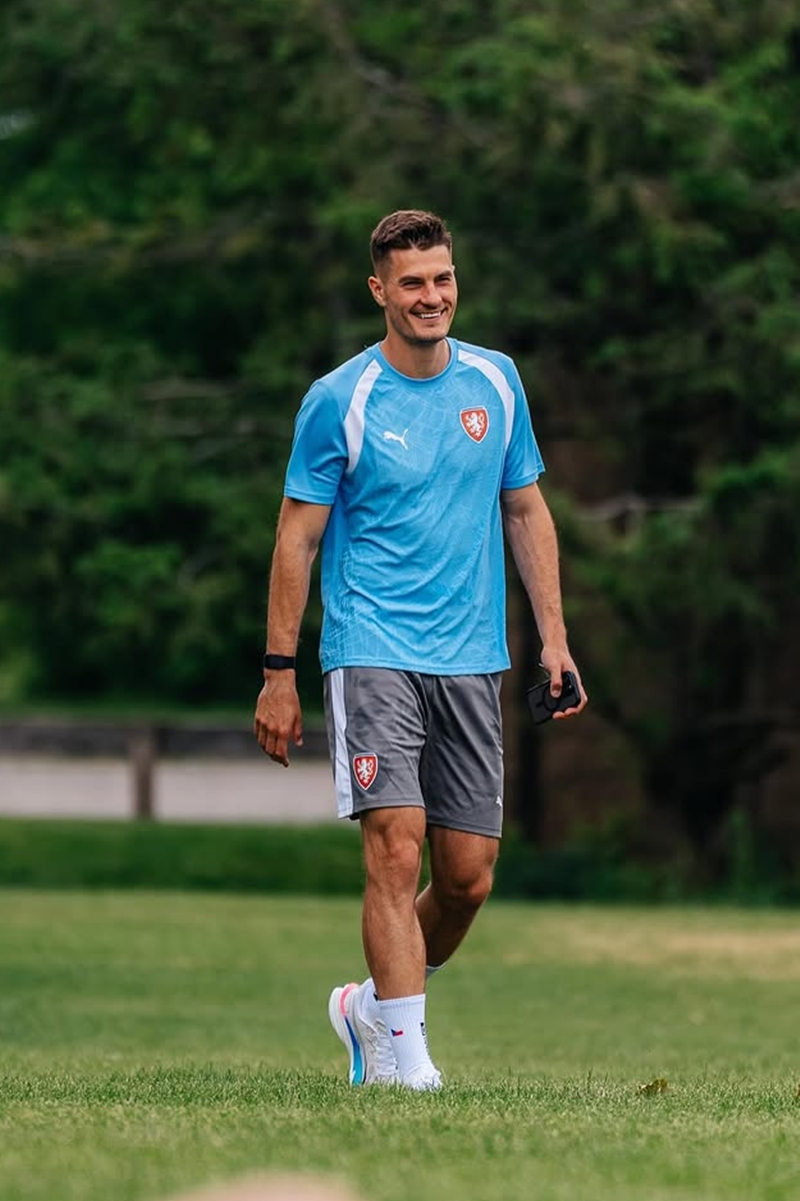 Foto colorida de homem com uniforme de time de futebol. Ele está em gramado - Metrópoles