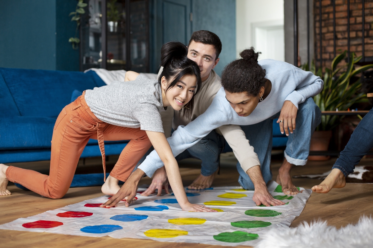 Foto colorida de grupo de adultos brincando com jogo