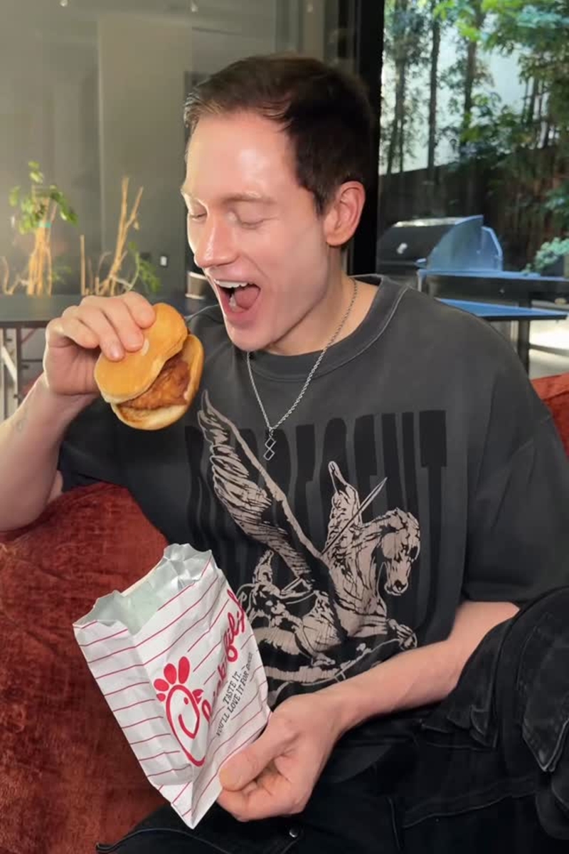 Foto colorida de homem comendo hambúrguer - Metrópoles