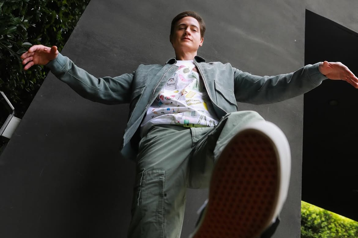 Foto colorida de homem em pé dando a entender que irá pisar em câmera - Metrópoles
