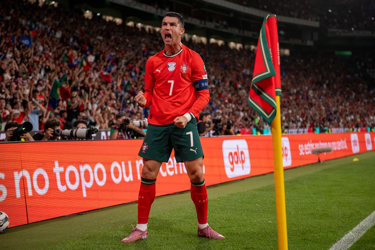 Foto colorida de homem com o uniforme da Seleção de Portugal comemorando gol em campo - Metrópoles