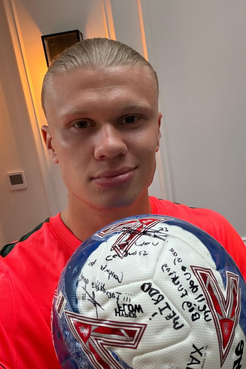 Foto colorida de homem fazendo selfie com bola de futebol - Metrópoles