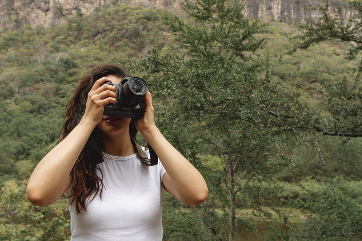Imagem colorida de pessoa fotografando na natureza