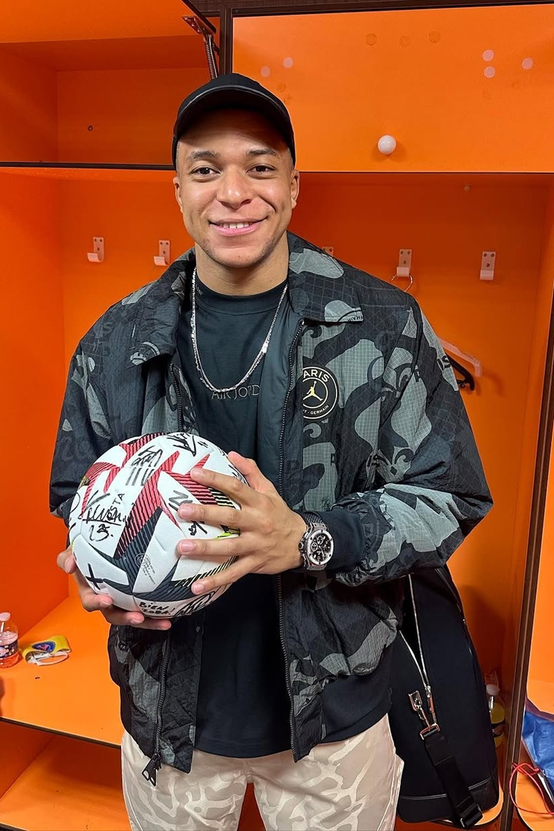 Foto colorida de homem segurando bola de futebol - Metrópoles