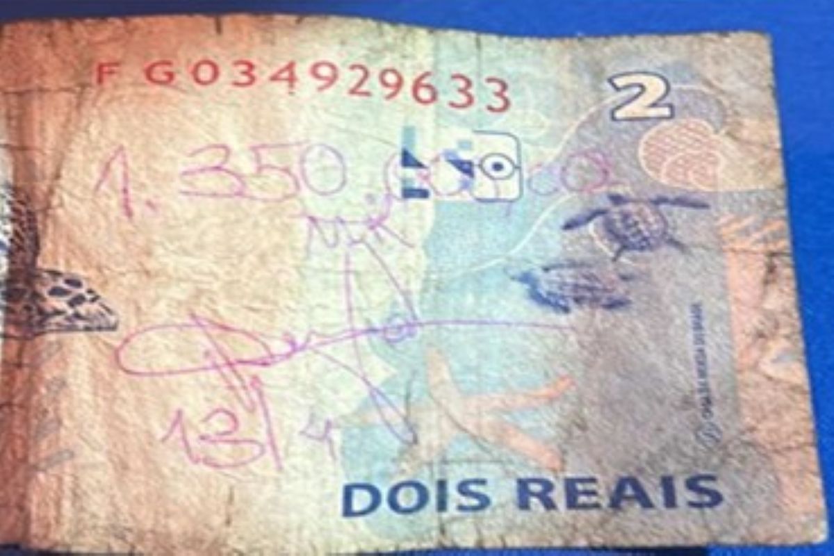 Nota de R$ 2 com valor escrito, usada como recibo de transferência pelos suspeitos