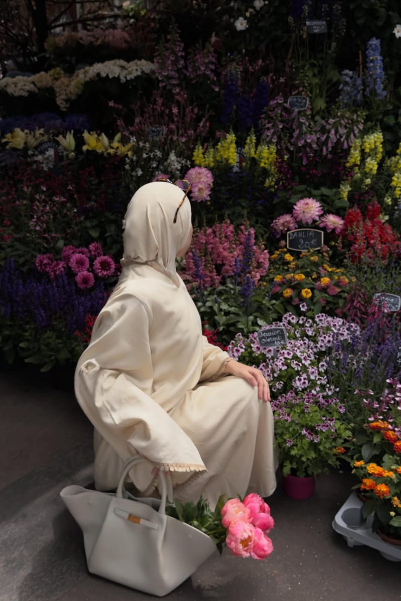 Foto colorida de mulher com hijab em loja de flores - Metrópoles