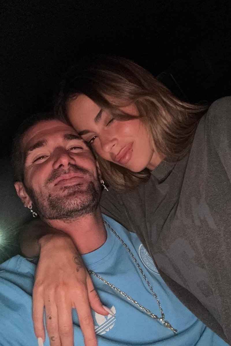 Foto colorida de homem e mulher abraçados posando para uma selfie - Metrópoles