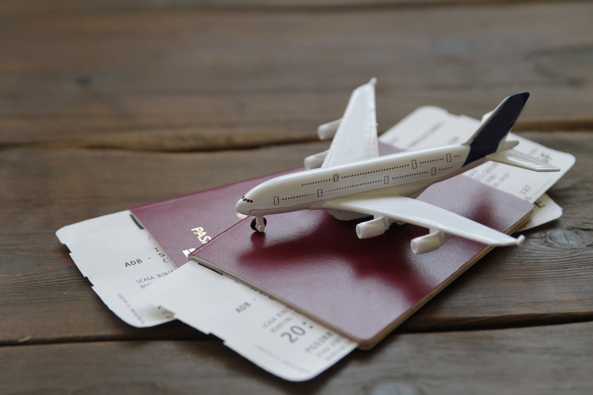 Foto colorida de avião de brinquedo sobre passaportes e cartões de embarque - Metrópoles