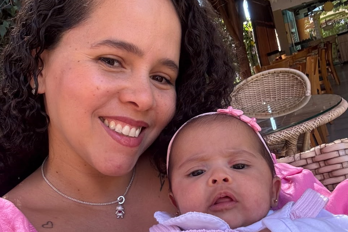 Foto de uma mãe segurando seu beb~e, ambas vestindo roupa cor de rosa - Metrópoles.