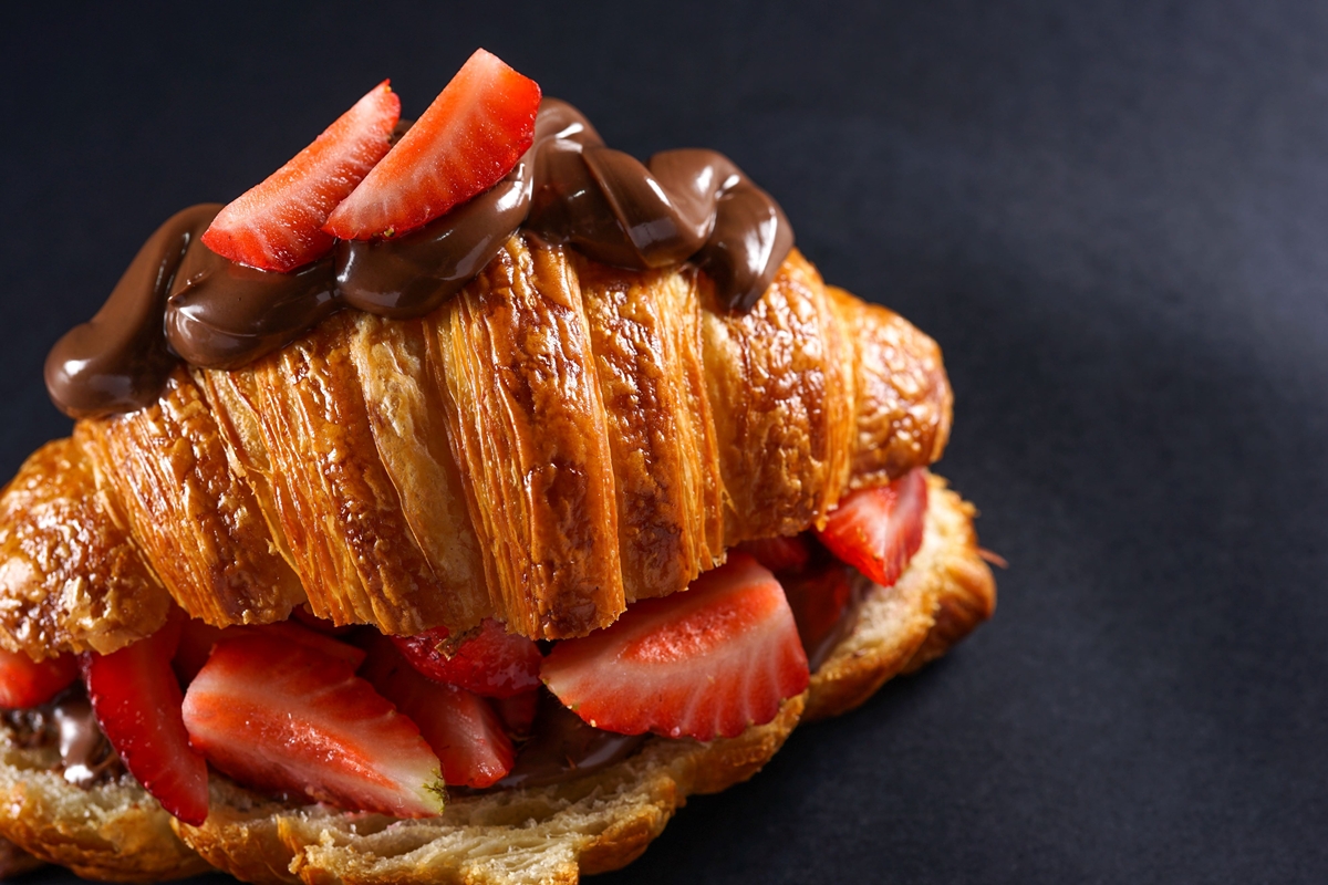 Na imagem colorida, um croissant recheado com morango e Nutella 