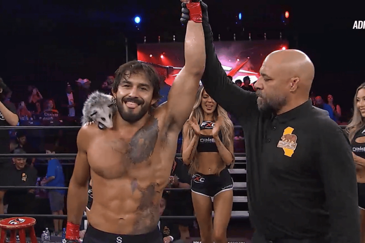 Lutador de MMA comemora vitória em evento com gambá de estimação