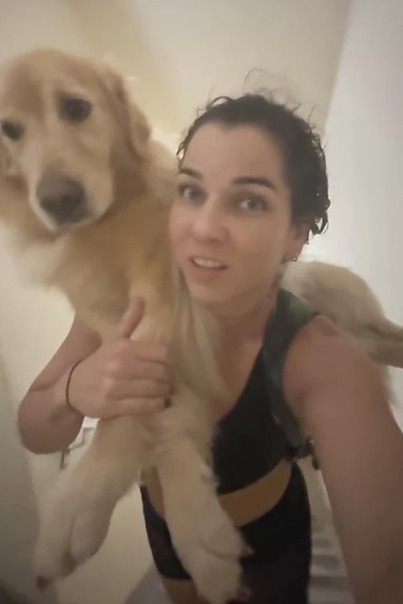 Imagem colorida de uma mulher carregando um cachorro golden nas costas - Metrópoles