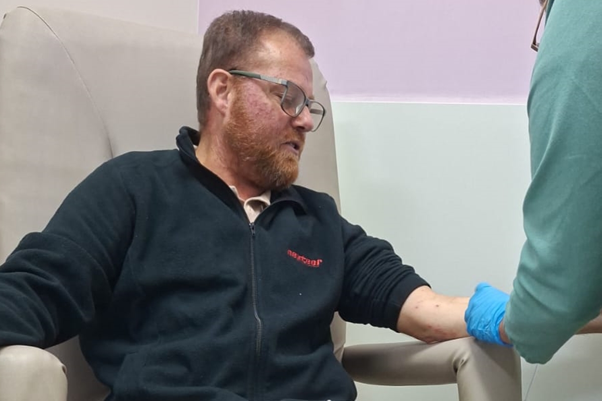 Foto colorida de homem em ambiente hospitalar com tubos de medicação conectados ao seu braço - Metrópoles.