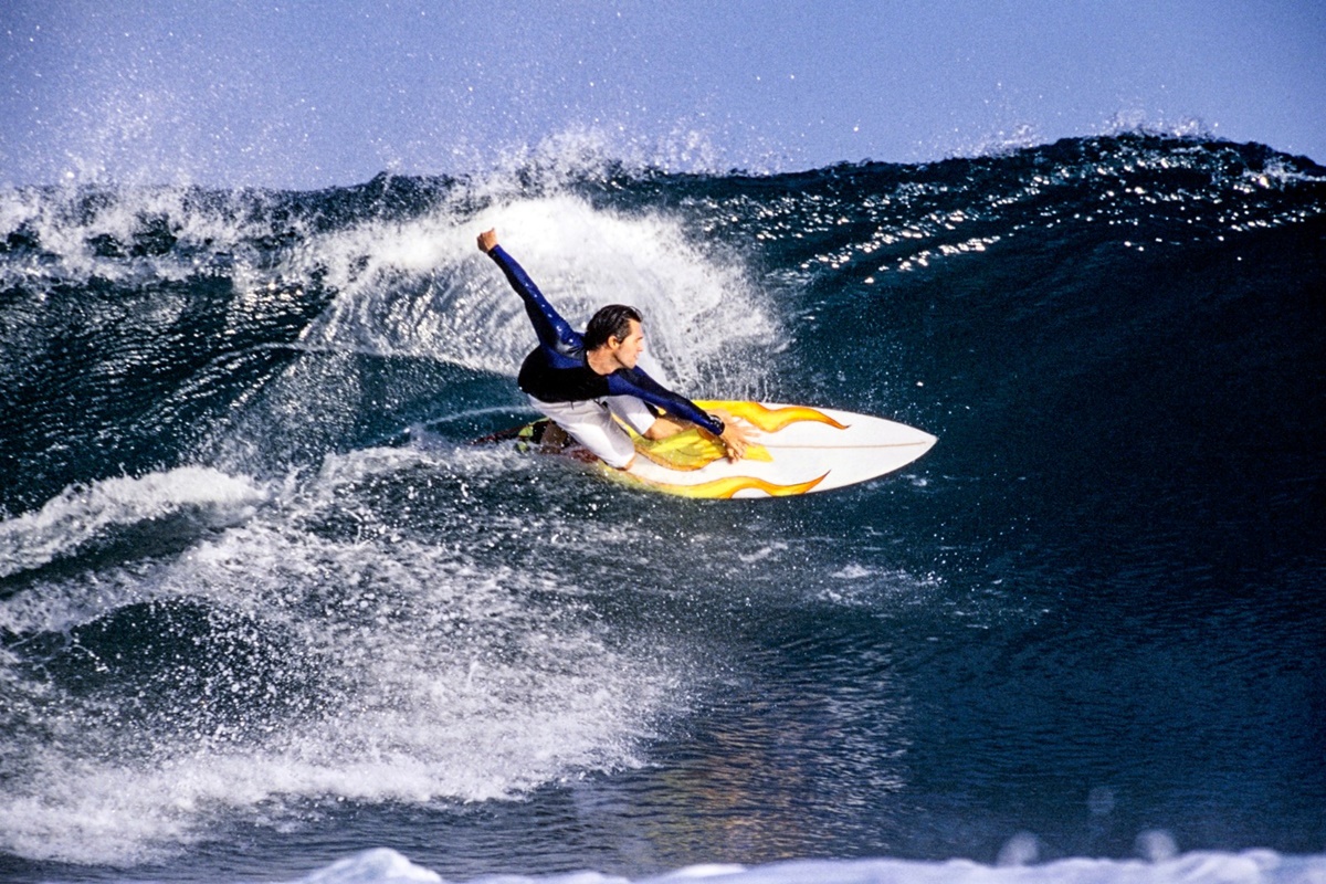 Surfista em prancha, ao surfar em onda em Rote, na Indonésia