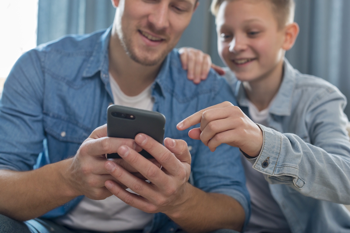 pai e filho no celular para evitar riscos à criança